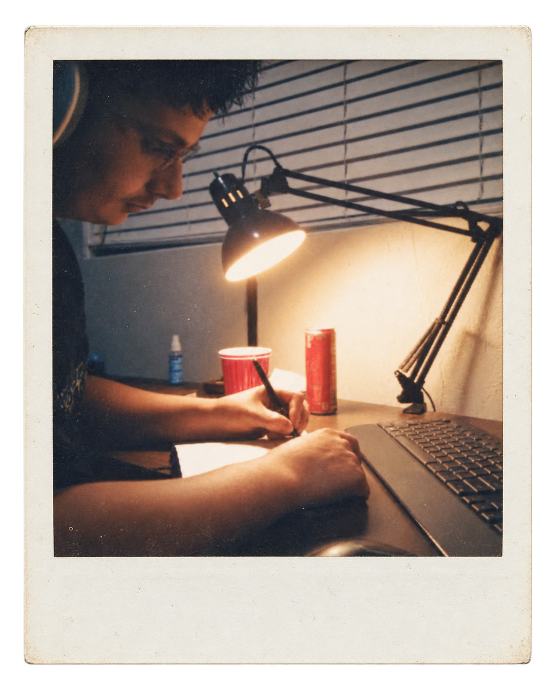 Writing study notes beside my laptop under a desk lamp.